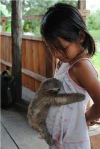 Small pet hugging girl's belly on near a river.