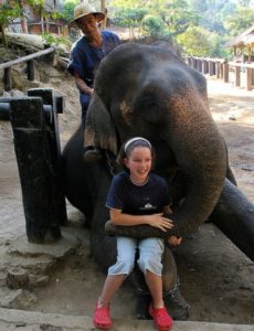 Elephant and girl hugging on near a river.